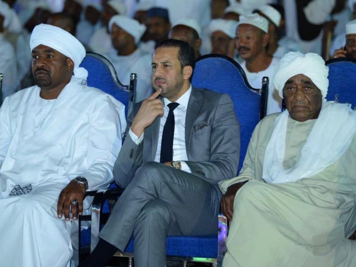 Kamal Benali seated in the front row at an official ceremony in Sudan